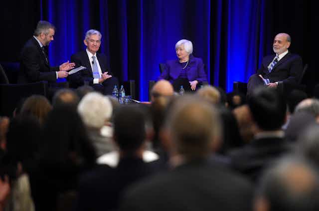 Janet Yellen, Ben Bernanke and Jerome Powell sit on a stage together