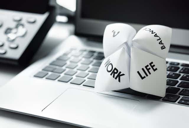 Origami fortune teller on laptop depicting options of work or life or balance.