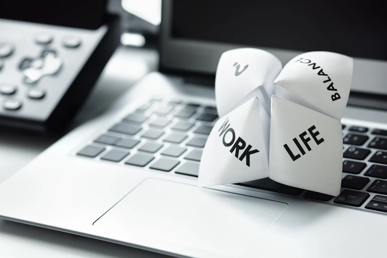 Origami fortune teller on laptop depicting options of work or life or balance.