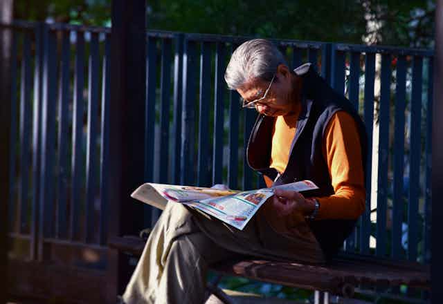older man reading a newspaper