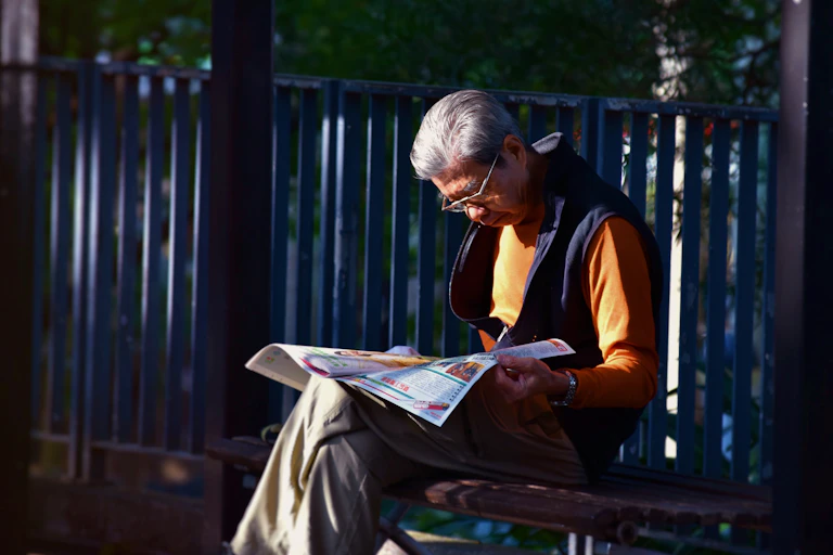 older man reading a newspaper