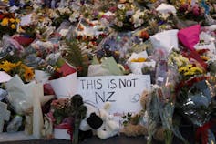 Bouquets of flowers piled up at a memorial