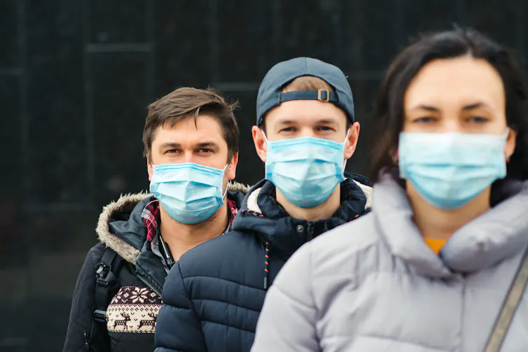 Three young people in masks