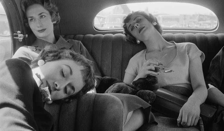 Three women in a car, two of whom are asleep.