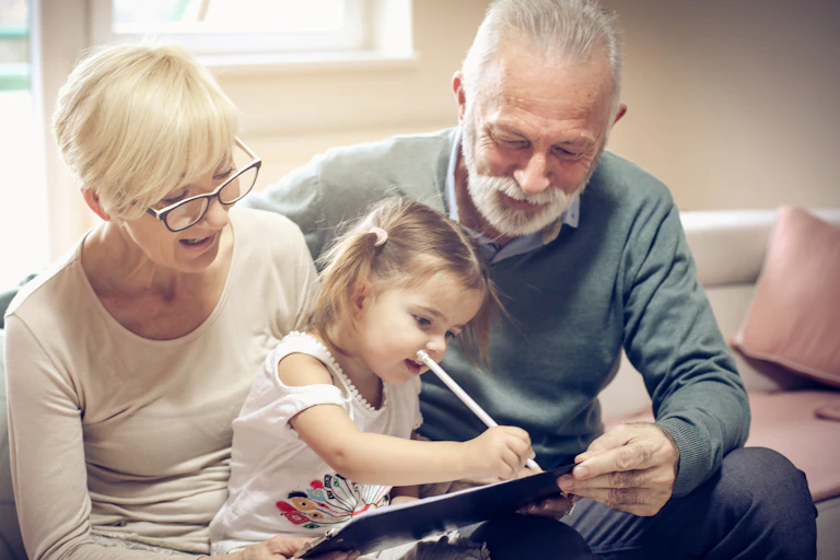 Grandparents with a granddaughter with pencil.