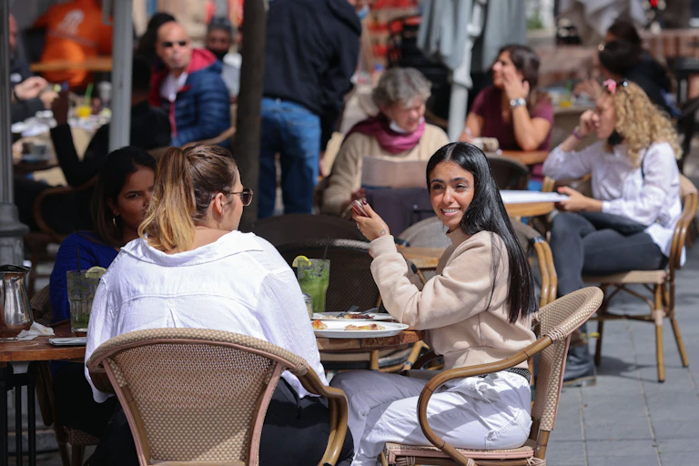 A groups if Israelie diners enjoy a meal outside
