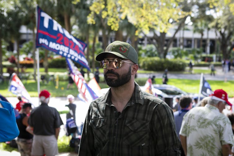 A man in sunglasses stands outside