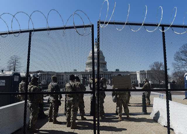 Soldiers and barbed wire block the way to the US Capitol