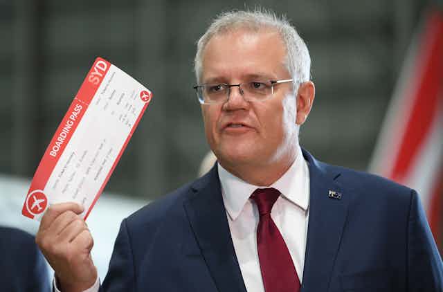 Australian prime minister Scott Morrison holding a dummy boarding pass.