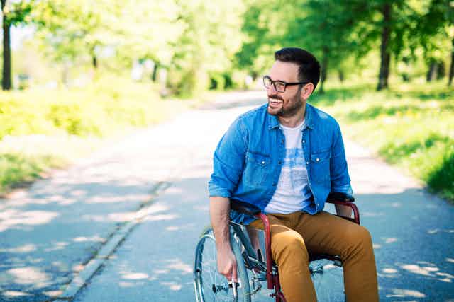 Man in wheelchair in park smiling