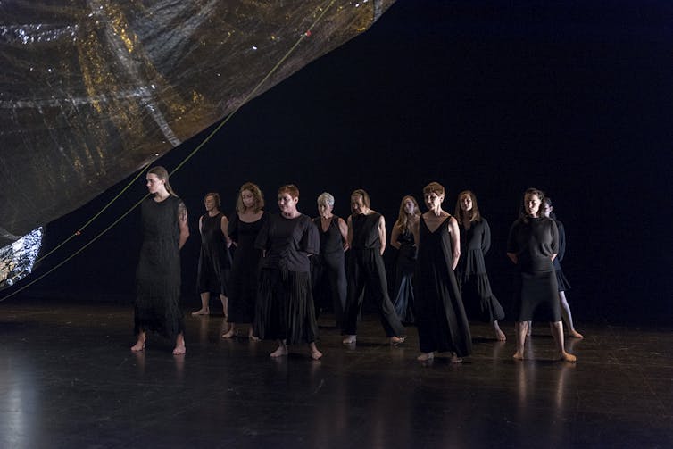 A mass of women in black dresses.