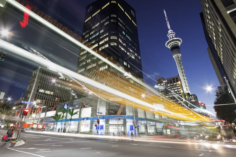 Auckland at dusk with a trail of lights in the city's streets