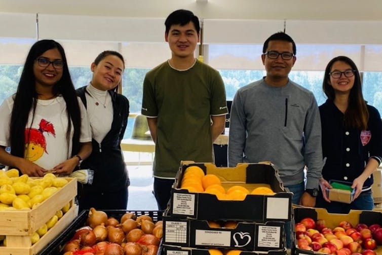 university students at a fresh produce market stall