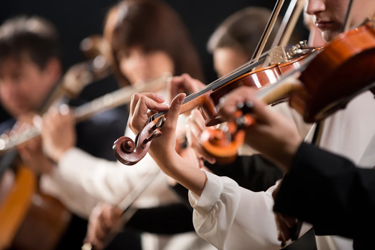 A blurred picture of people playing in an orchestra.