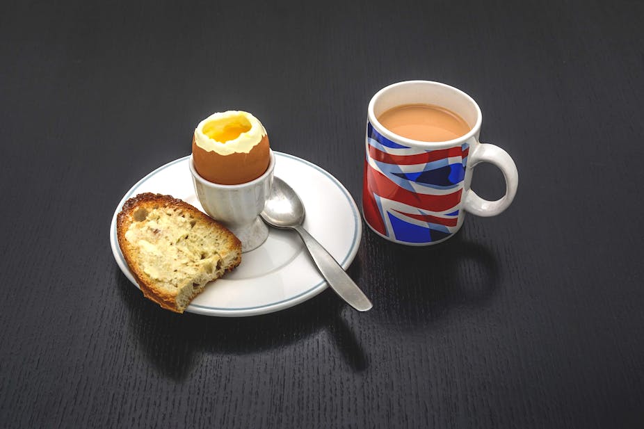 Boiled egg and toast on a plate next to a Union Jack mug filled with tea