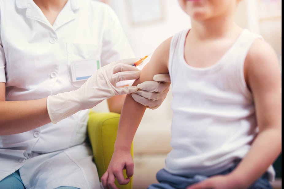 Child receives vaccination from nurse.