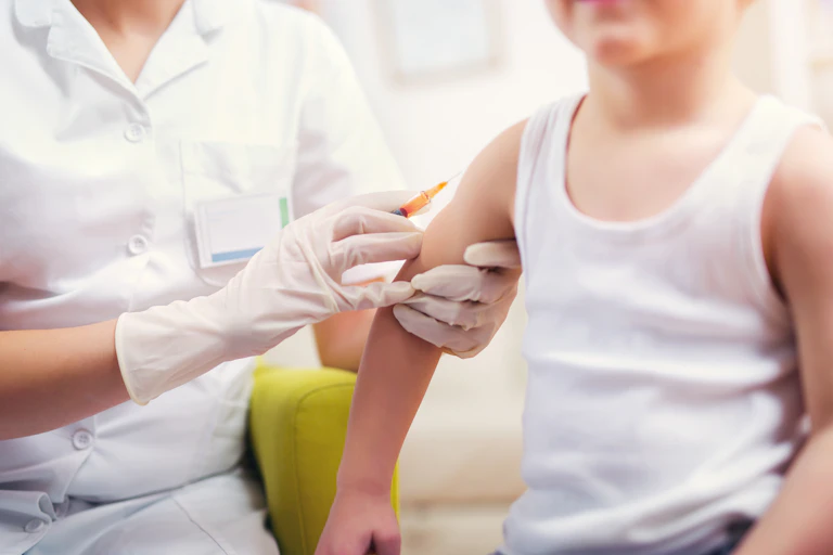 Child receives vaccination from nurse.
