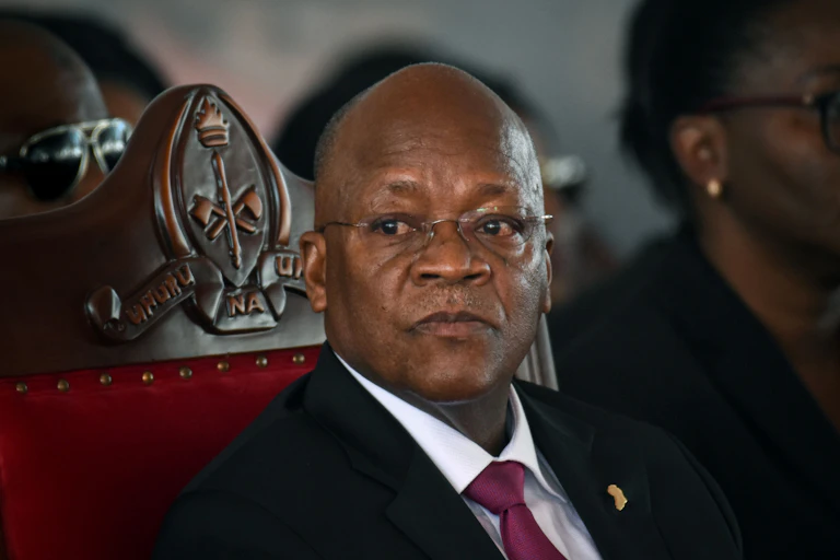 Man seated, in black suit and red tie