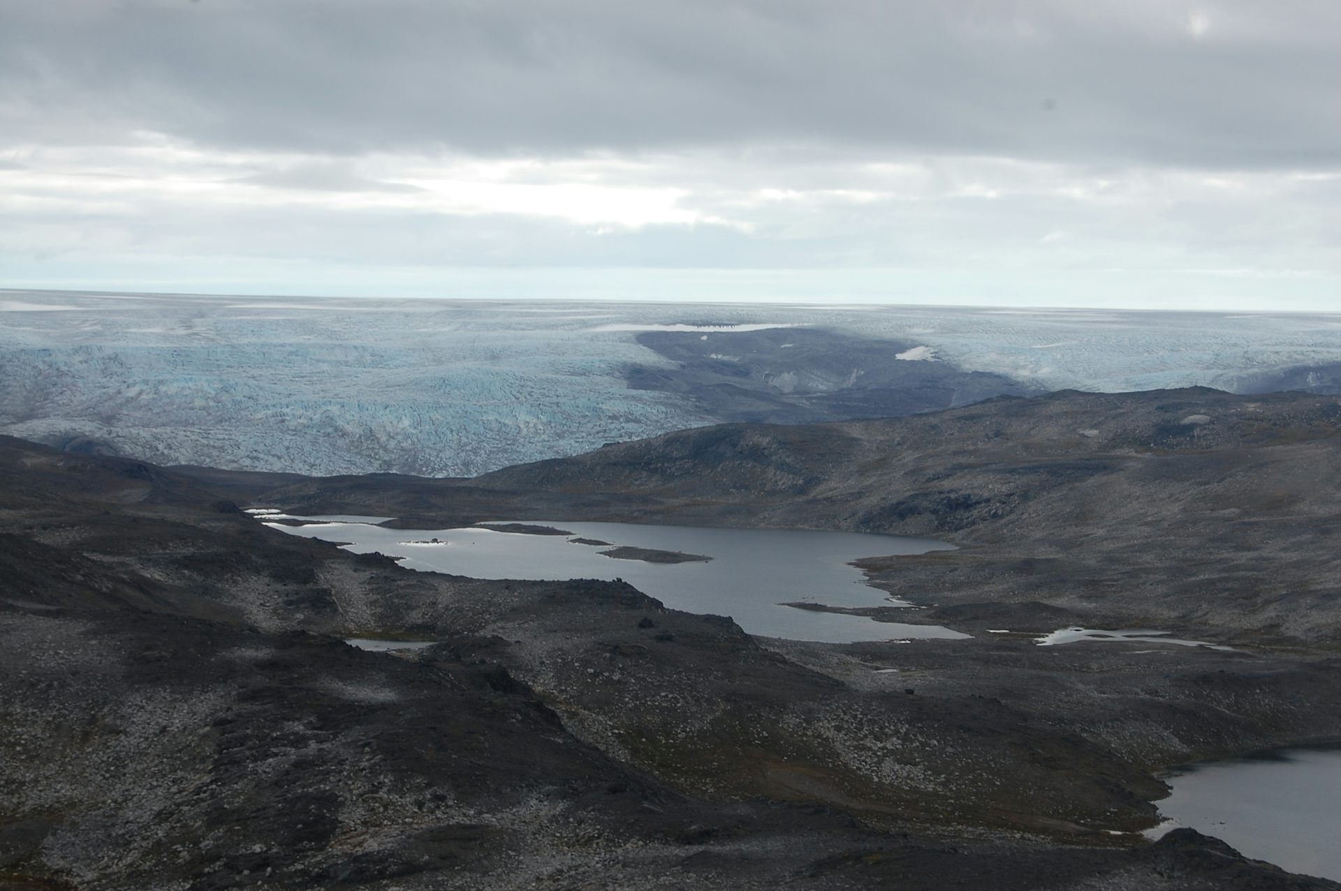A rocky barren landscape with a glacier in the distance