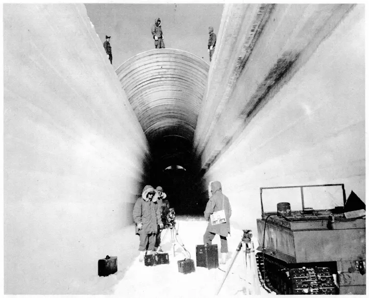 Workers cover a trench to build the under-ice military base