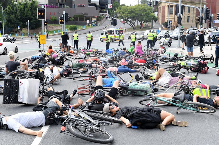 cyclists protest by staging a 'die-in' at a city intersection