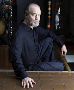 Photo of author Douglas Coupland sitting on steps.