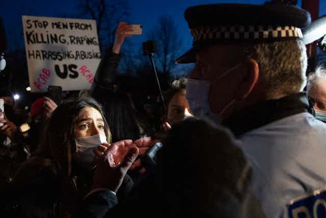 A protester and police officer face each other in Clapham