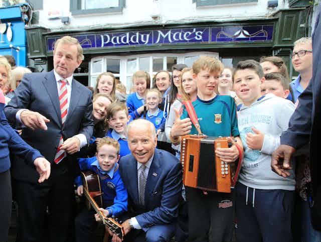 Joe Biden kneels outside Paddy Mac's bar in Ballina, County Mayo durng a vice-presidential visit to Ireland in 2016.