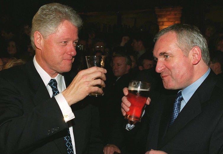 Bill Clinton and Taoiseach Bertie Ahern drinking beer.