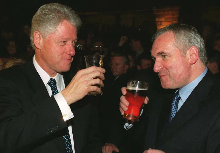 Bill Clinton and Taoiseach Bertie Ahern drinking beer.