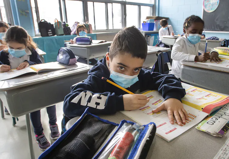 Students in a Grade 1 class wear masks.