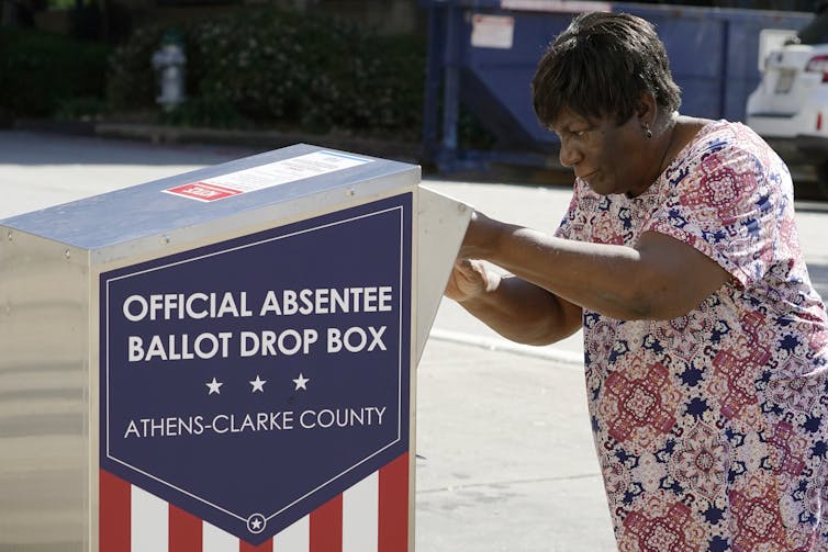 A woman dropping off her ballot in a drop box in Athens, Georgia