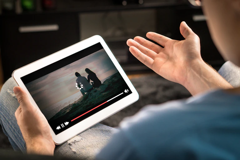 A man looks frustrated when a video on his tablet fails to load
