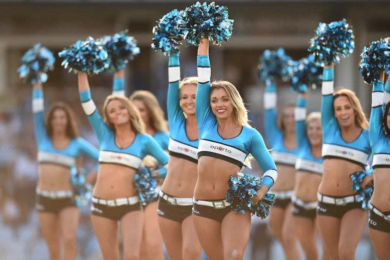 Cheerleaders in skimpy outfits with pom poms.
