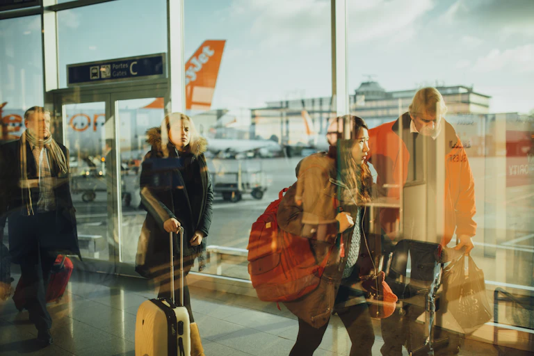 Young travellers walk through an airport terminal with suitacases