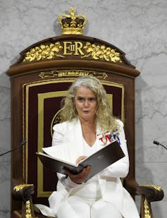 Payette, in a white suit, reads the throne speech.