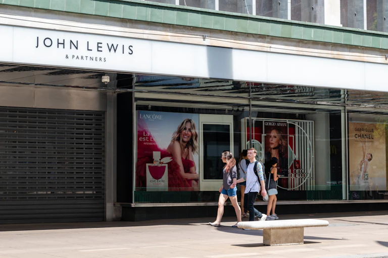 A couple walk past a closed John Lewis department store.