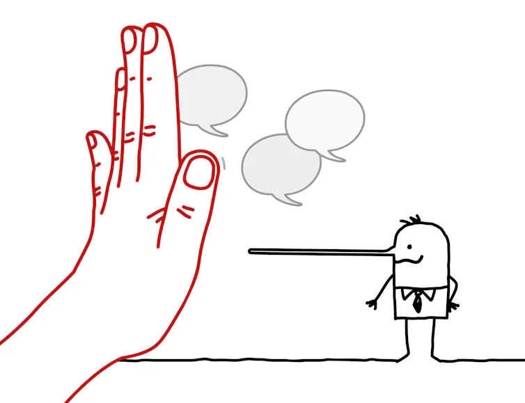 A hand stopping a Pinocchio-nosed person