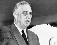 FDR speaks in a black-and-white photo.
