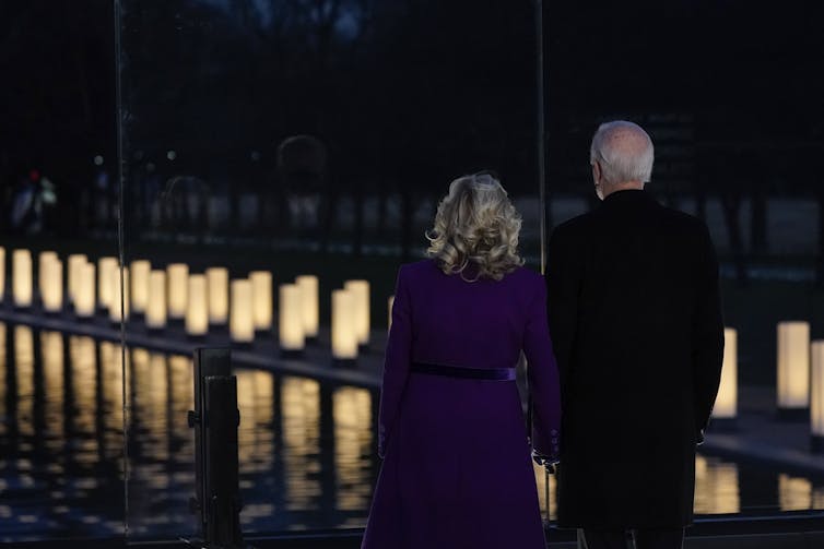 Joe and Jill Biden look out at lights during a COVID-19 memorial.