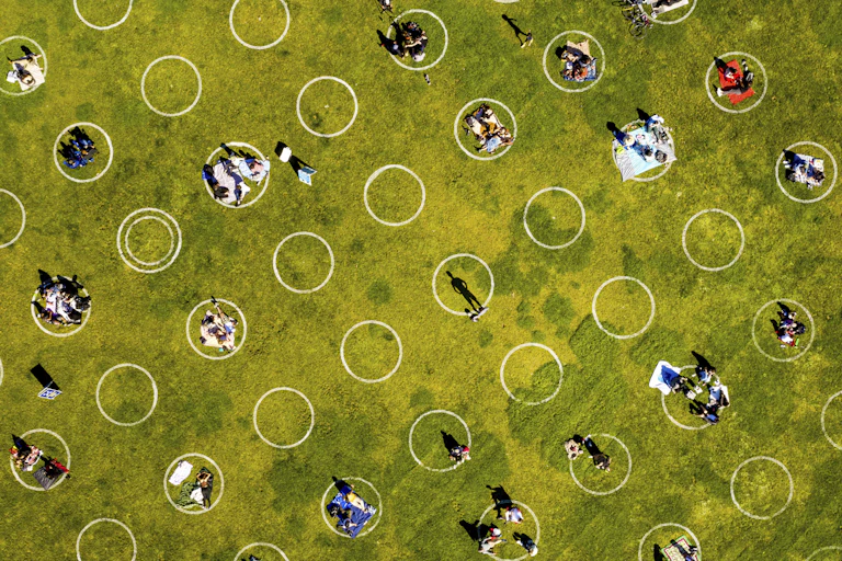 White social distancing circles painted on grass