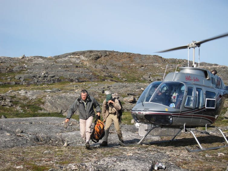 two men leaving a helicopter