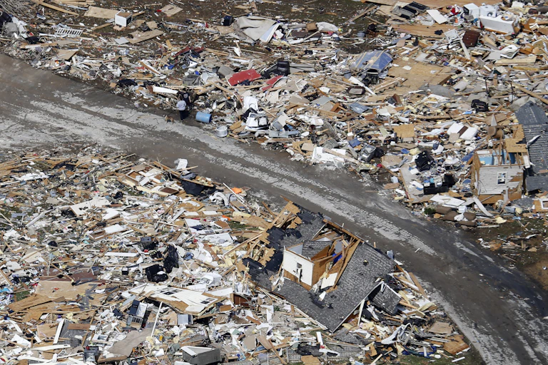 A road separates swaths of storm-demolished homes.