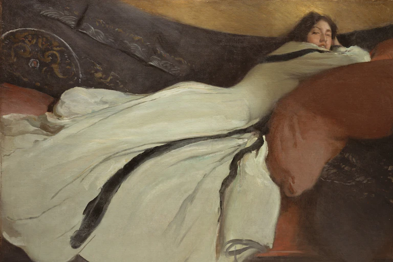 A woman in a flowing dress lies in repose.