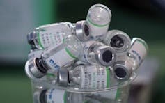 Empty vials of China's Sinopharm vaccine sit in a cup