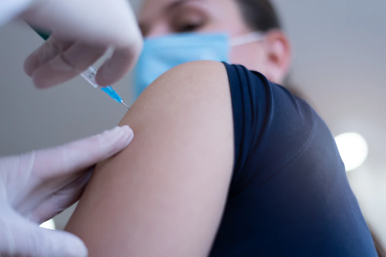 A vaccine is injected into a person's arm.