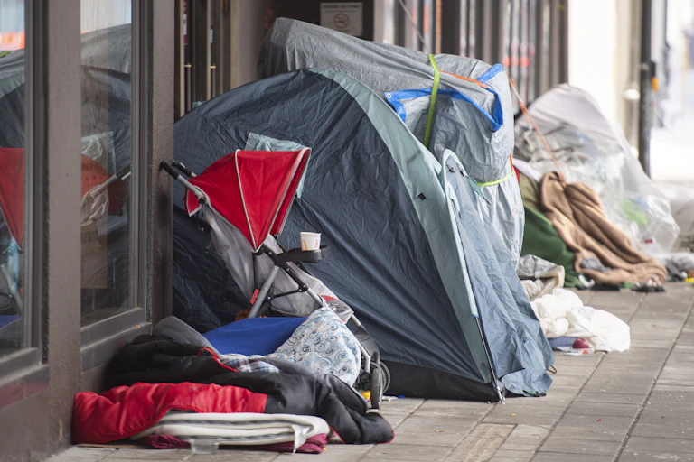 Homeless tents and a stroller next to department store doors
