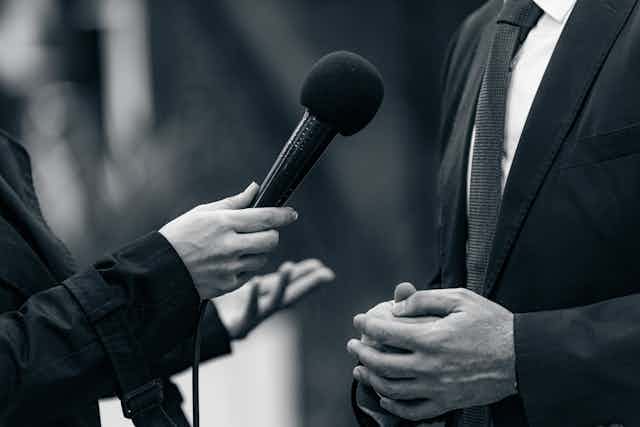 A microphone is held for an interview