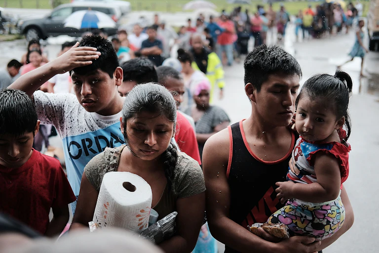 Migrants receive paper towels and other supplies