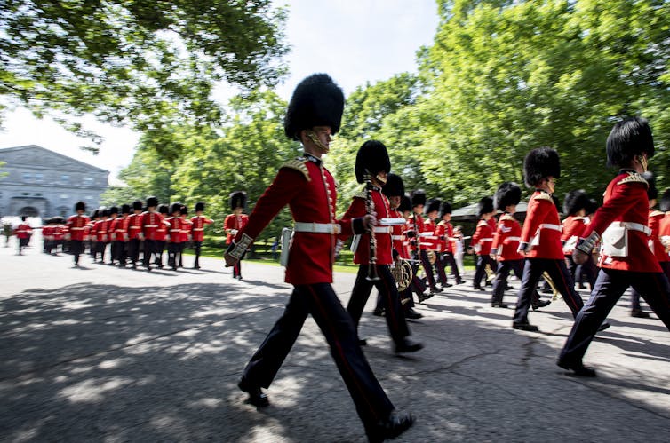 Members of the Ceremonial Guard march past Rideau Hall